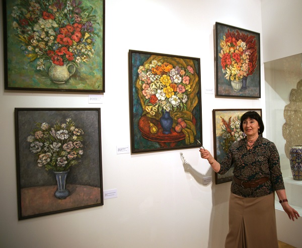 Художник Елена Гурвич  у своих работ на выставке "Цветы"