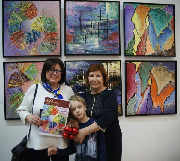 Художник  Марина Райкова  с гостями вернисажа  в ЦДХ на фоне своих работ Выставка  "Ландшафты абстракции"