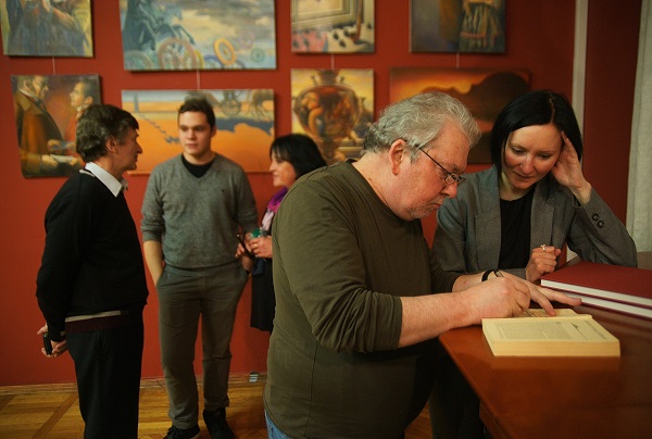 Художник  Сергей Чайкун подписывает книгу  Издательства  "Вита Нова" со своими иллюстрациями на Вернисаже в Доме Кино