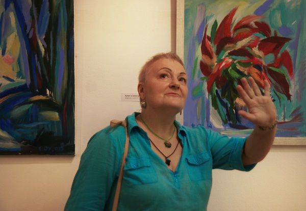Художник Маргарита Юркова на фоне работ Евгения Окиншевича  на выставке в Российской Академии художеств 19 июля 2016 года 