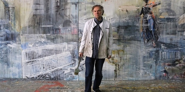 Художник  Валерий Кошляков на фоне своей работы