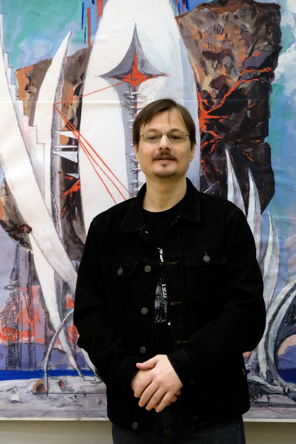 Фотограф  Павел Товкач на фоне работы  Виктора Орловского выставка   "Космопластицизм"